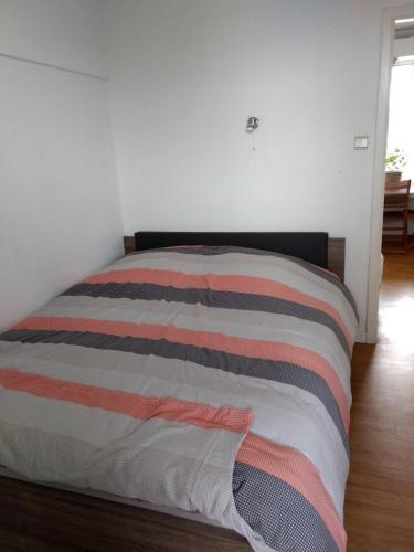 a bed in a bedroom with a striped blanket at Vosseslag Beach - De Haan in De Haan