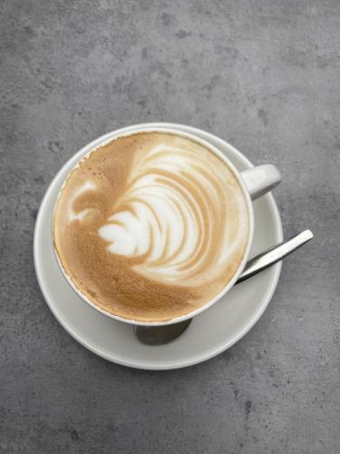een kopje koffie op een bord op een tafel bij Apartment In de Wolken in Oostwoud