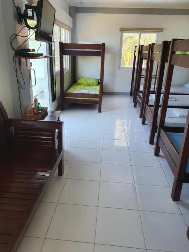 a room filled with lots of bunk beds at L & M Hearthstones Lodge in Oslob