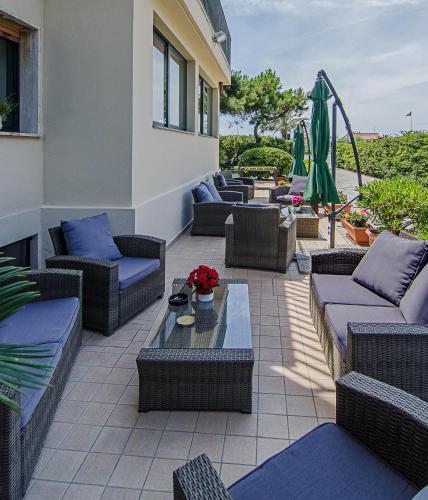 a patio with couches and chairs and a table at Hotel Paris in Lido di Camaiore