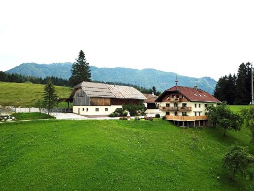 ein Haus auf einem Hügel mit einem grünen Feld in der Unterkunft Möselberghof in Abtenau