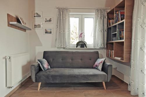 uma sala de estar com um sofá e uma janela em Przystanek Tykocin - domki gościnne w sercu Podlasia em Tykocin