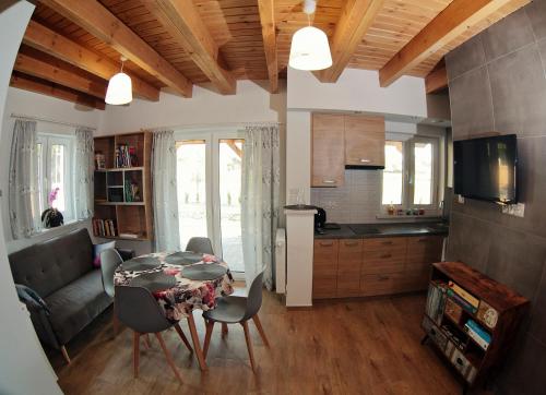 a kitchen and living room with a table and chairs at Przystanek Tykocin - domki gościnne w sercu Podlasia in Tykocin