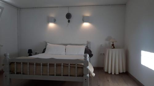 a white bedroom with a bed and a table at Gites de Frans in Frans