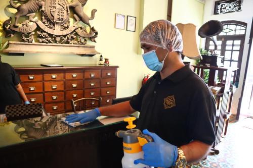 
a man in a blue shirt is working in a kitchen at Museum Hotel in George Town
