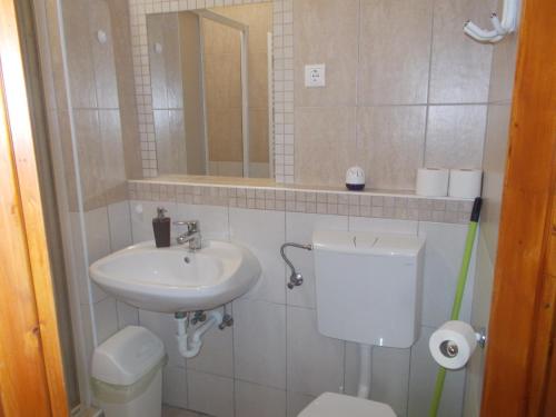 a bathroom with a sink and a toilet and a mirror at Hétkanyar Vendégház in Nagyvázsony