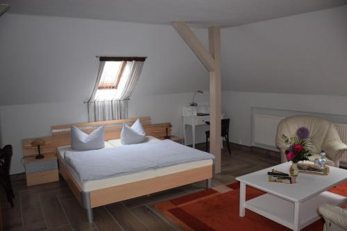 ギュストローにあるGästehaus Pension Heß - Das kleine Hotelのベッドルーム1室(ベッド1台付)、リビングルーム(テーブル付)