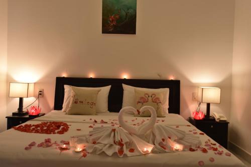 a bedroom with a bed with a heart made out of roses at Flamingo Villa Homestay - Big Rooms with Balcony - Close to Hoi An Old Town 200m & Temple Bridge - Large Outside Pool for Sun Bathing in Hoi An