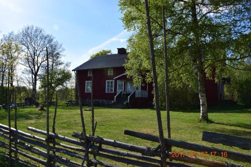 a red house with a fence in front of it at STF Kapellskär Hostel in Gräddö
