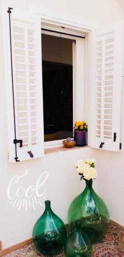 two green vases sitting in front of a window at meridiano12 in Favignana