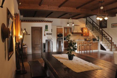 a kitchen and living room with a wooden table in a room at Quinta Sobral Prestige - Rustic House in Sobral de Monte Agraço