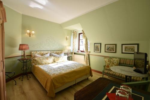 a bedroom with a bed and a couch and a window at Pension zur Königlichen Ausspanne Dresden in Dresden
