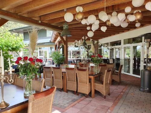 uma sala de jantar com mesas, cadeiras e flores em Hotel Martensplek em Tiendeveen