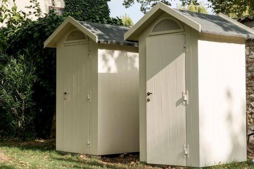 two white storage sheds sitting in the grass at La Barchessa di Villa Pisani in Lonigo