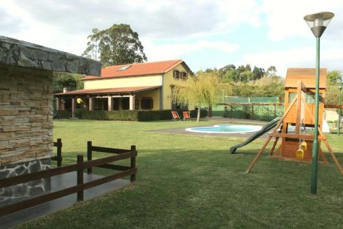 a yard with a playground with a slide and a house at Quinta Sobral Prestige - Rustic House in Sobral de Monte Agraço