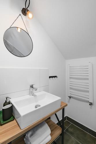 a bathroom with a white sink and a mirror at Aparthotel Narciarska 2 in Korbielów