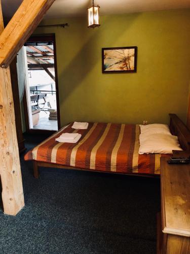 a bed in a room with a green wall at Karczma Młyn in Kamienica