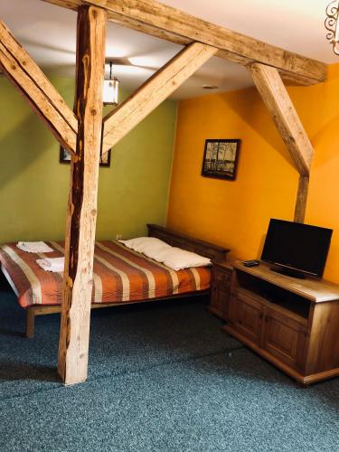 - une chambre avec 2 lits et un ordinateur portable sur un bureau dans l'établissement Karczma Młyn, à Kamienica