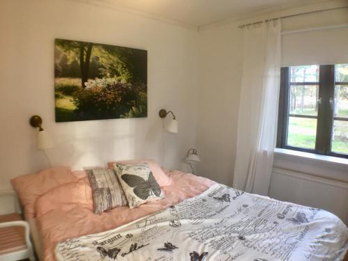 Schlafzimmer mit einem Bett und einem Fenster in der Unterkunft Davidslids cottage in Löddeköpinge