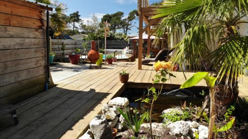a garden with a wooden deck with plants at Laniakea in Lacanau-Océan