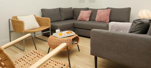 ein Wohnzimmer mit einer Couch und Stühlen und einem Tisch in der Unterkunft Home Sweet Home Main St Pamplona in Pamplona