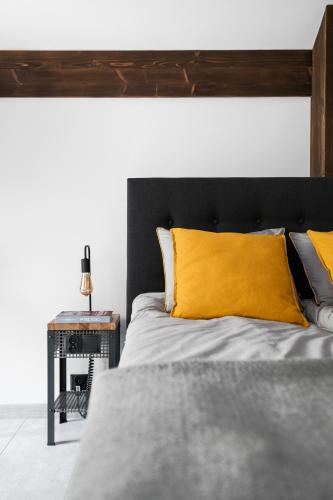 a bedroom with a bed with yellow pillows and a table at Aparthotel Narciarska 2 in Korbielów