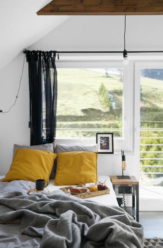 a bedroom with a bed with yellow pillows and a window at Aparthotel Narciarska 2 in Korbielów