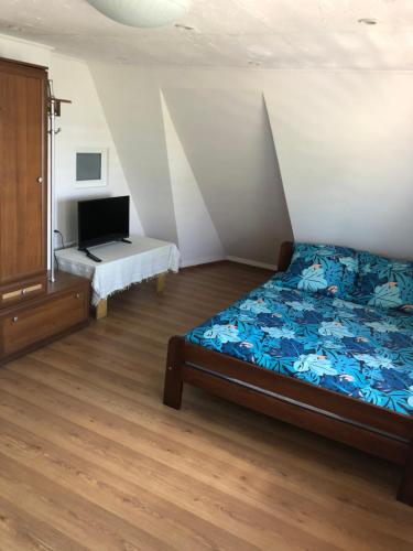 a bedroom with a bed and a desk in it at Pensjonat Krzyś in Nielisz