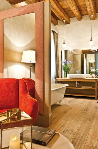 a living room with a red couch and a tub at La Barchessa di Villa Pisani in Lonigo