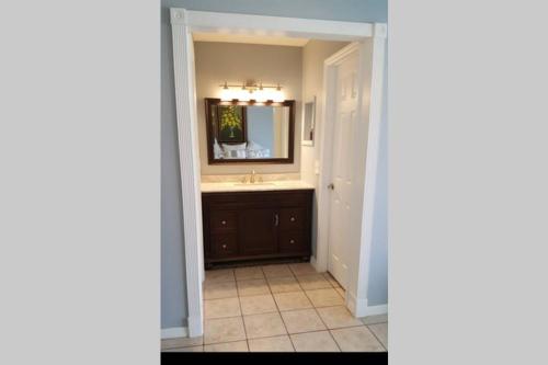 een badkamer met een wastafel en een spiegel bij Beautiful Florida Vacation Pool House in Port Saint Lucie
