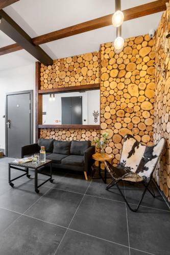a living room with a couch and a wall of logs at Aparthotel Narciarska 2 in Korbielów