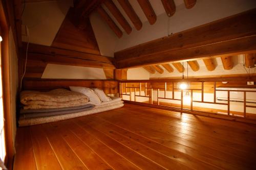 a large room with a bed in a room with wooden floors at GaEunChae 2 in Jeonju