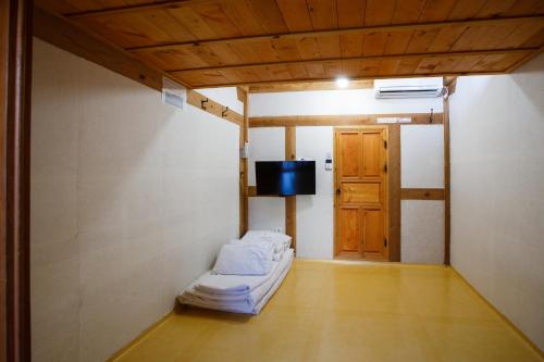 a room with a bed and a television and a door at GaEunChae 2 in Jeonju
