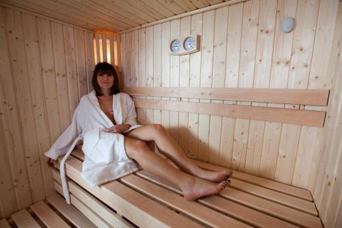 a woman is sitting in a sauna at Hotel Residence Villa Del Mare in Rimini