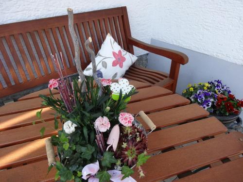 a wooden bench with a bunch of flowers on it at Haus Seidl in Bodenmais