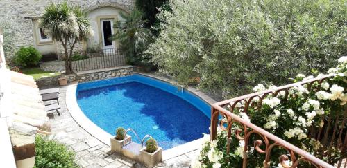 a swimming pool in front of a house at Gîte La Maison des Autres, climatisé, piscine partagée chauffée in Saint-Géniès-de-Malgoirès