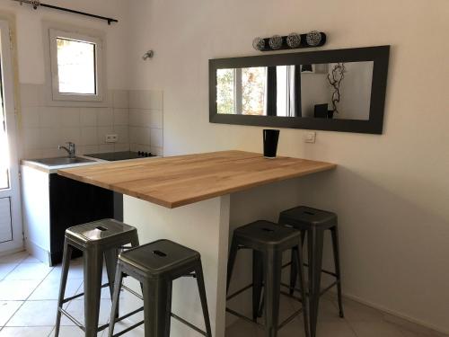 une cuisine avec un comptoir avec des tabourets et un miroir dans l'établissement Residence Pezza Cardo, à Porto-Vecchio
