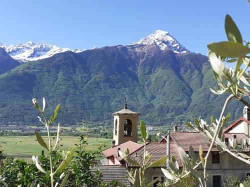 a church with a mountain in the background at B&B Monastero in Dubino