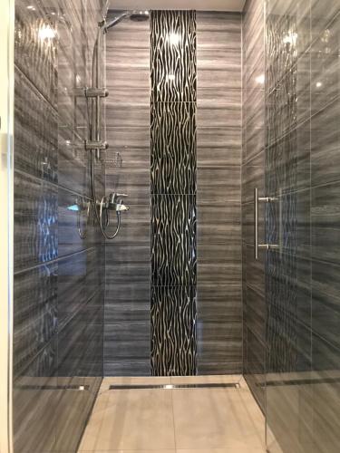 baño con ducha y puerta de cristal en Pension Kristalpark en Günzburg