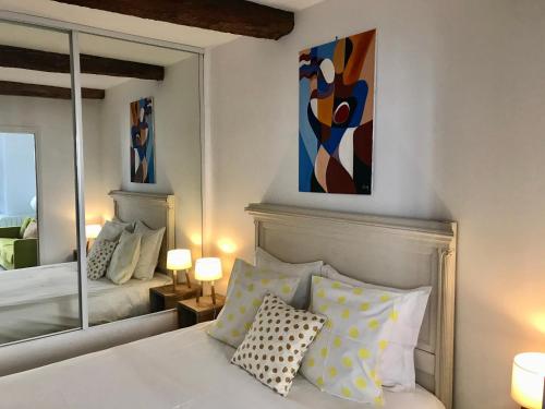 1 dormitorio con 1 cama y una pintura en la pared en La Maison du Courtil, Citron-Caramel, en Moustiers-Sainte-Marie