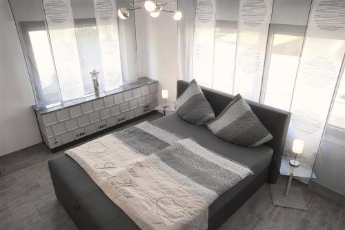 um quarto com uma cama com almofadas e janelas em Ferienwohnung Himmelreich em Bernkastel-Kues