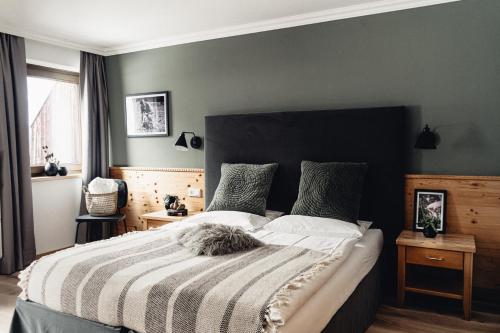 a bedroom with a large bed with a black headboard at Designhotel Sonnhof by Vitus Winkler in Sankt Veit im Pongau