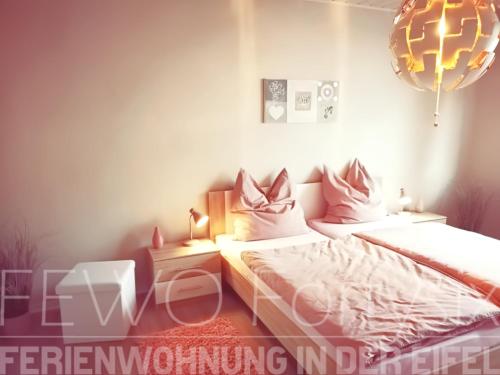 1 dormitorio con 2 camas y lámpara de araña en FeWo Fortysix en Mendig