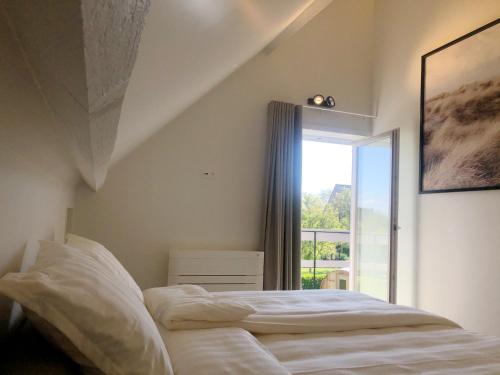 a bedroom with a bed and a large window at Villa Zuid in De Haan