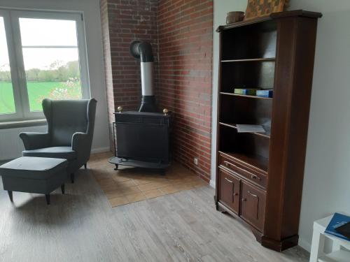 a living room with a wood stove and a chair at Ferienwohnung Schwalbennest in Hanerau-Hademarschen