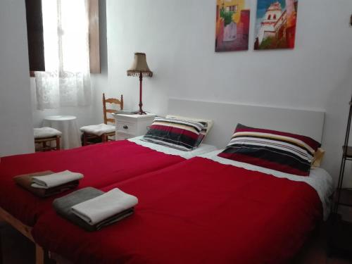 a bedroom with a red bed with towels on it at La Casa de la Vila in Ontinyent