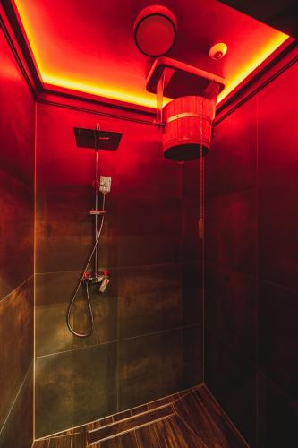 a bathroom with a shower with a red lighting at Aparthotel Narciarska 2 in Korbielów