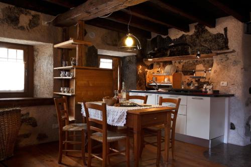 a kitchen with a table and chairs in a room at Dormì & Disnà in Val di Zoldo