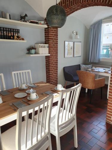 a dining room with a wooden table and chairs at Hotel Freihof am Roland in Wedel