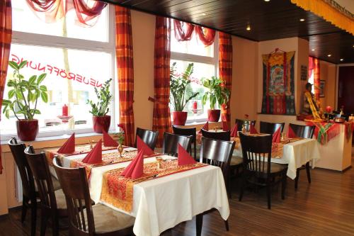 a restaurant with tables and chairs with red napkins on them at Hotel Hubbert in Castrop-Rauxel